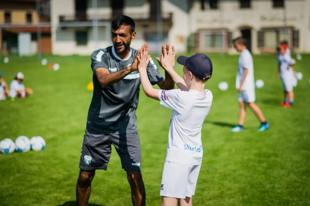 Trainer und Kind klatschen beim Training der AP Skills Academy ab
